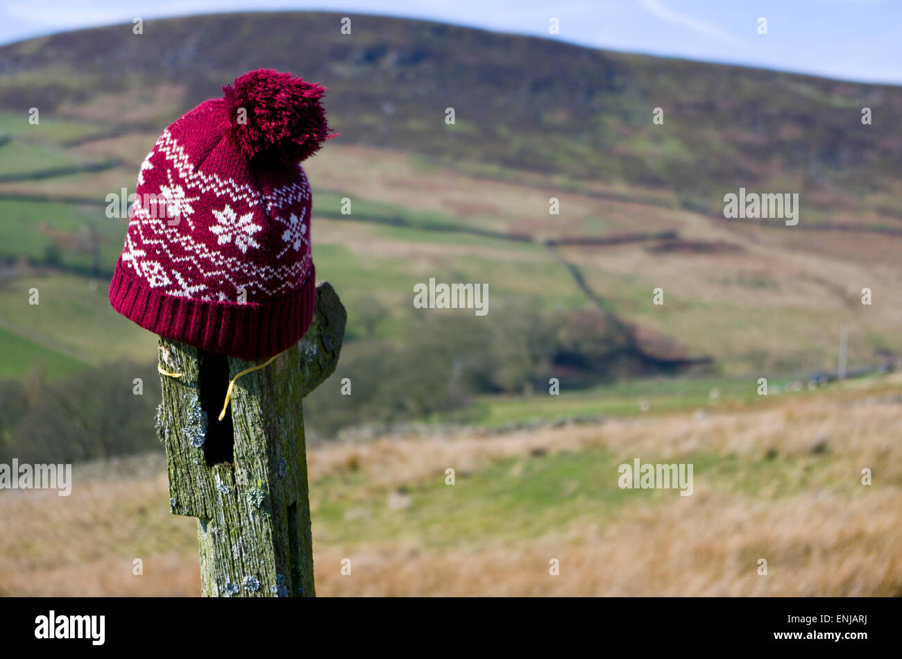 Scartato Red lanosi Bobble Hat su un sentiero pubblico segno, Dane Valley, il Parco Nazionale di Peak District, Staffordshire, England, Regno Unito Foto Stock