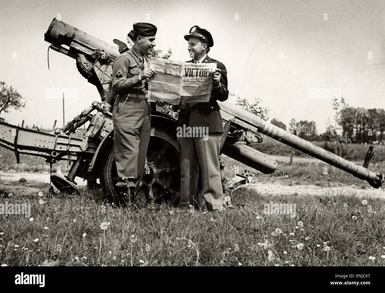 Vittoria in Europa. Leggere i soldati di vittoria, in piedi da un tedesco 88 mm pistola a Verdun, Francia su VE Day 1945 Foto Stock