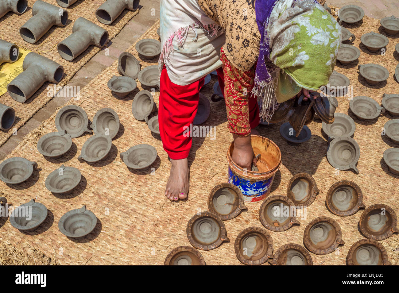 Bhaktapur, Nepal - 20 marzo 2015: donna immissione potteries a secco sulla piazza di ceramiche. Foto Stock