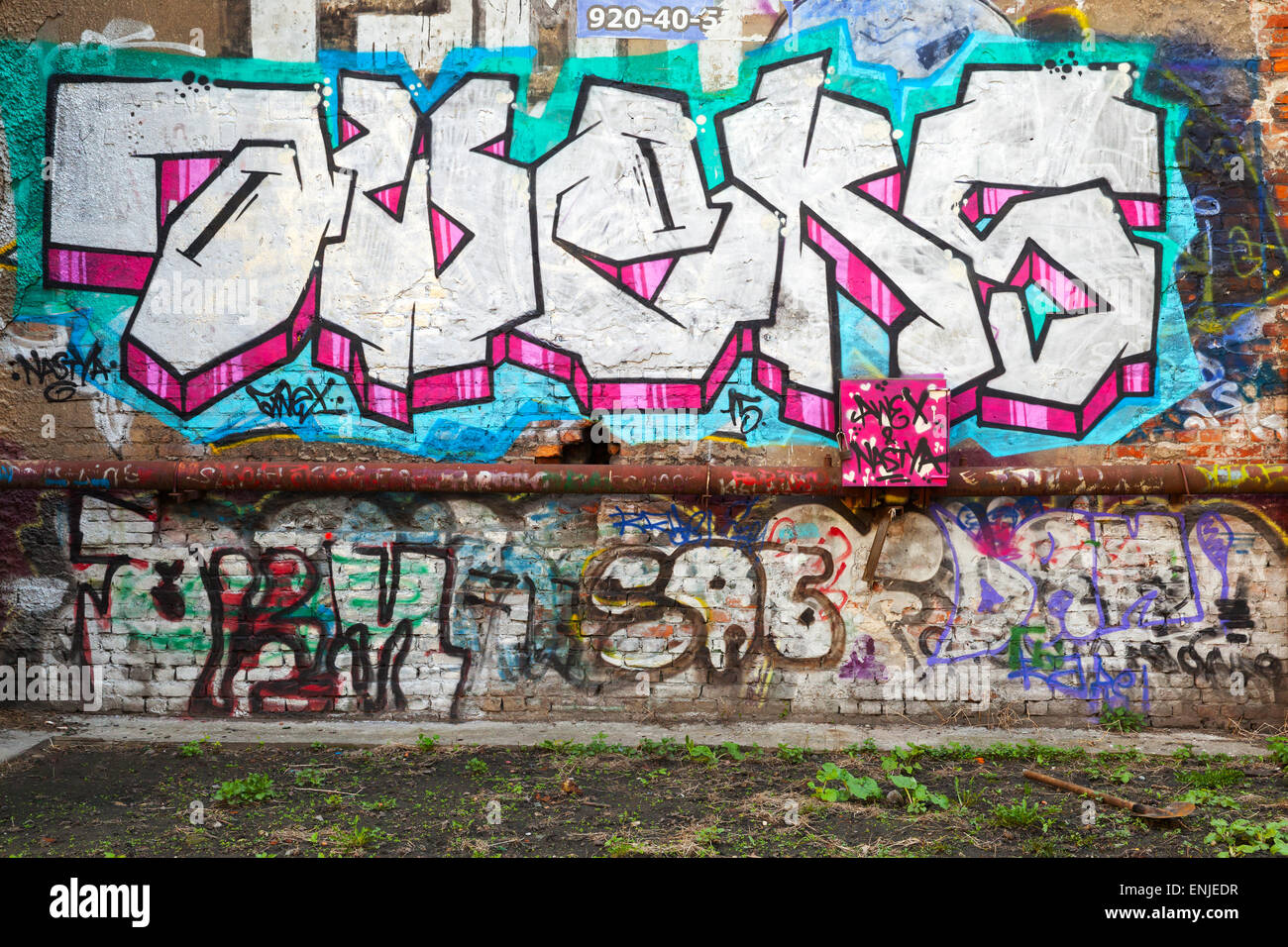 San Pietroburgo, Russia - 6 Maggio 2015: abbandonato urban cortile con colorati graffiti astratti modelli di testo sui mattoni vecchi wal Foto Stock