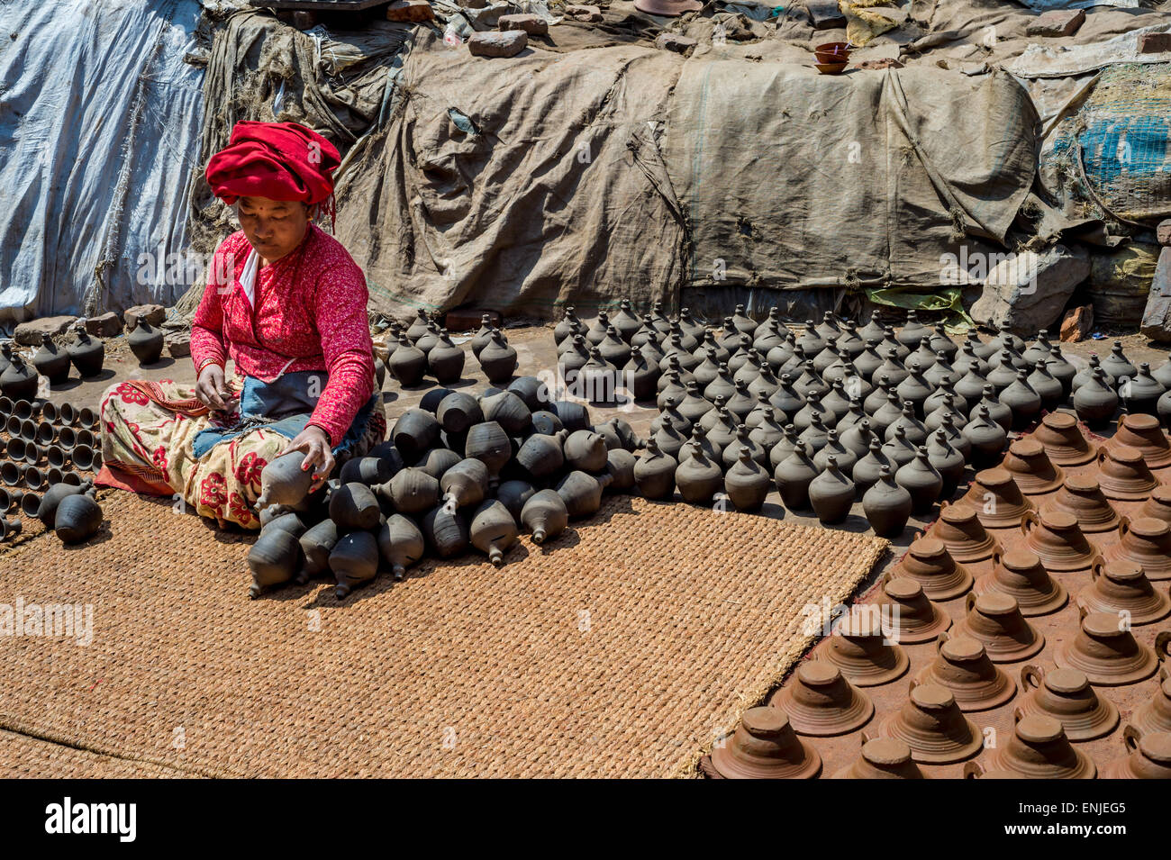 Bhaktapur, Nepal - 20 marzo 2015: donna immissione potteries a secco sulla piazza di ceramiche. Foto Stock