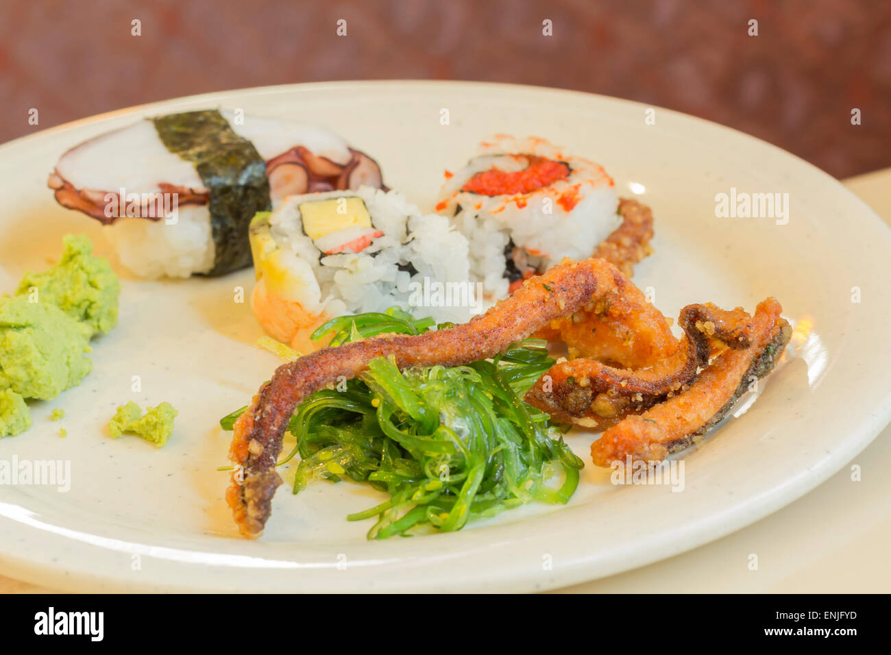 Assortiti piatto di frutti di mare con calamari fritti gambe alghe insalata di polpo sushi e wasabi Foto Stock