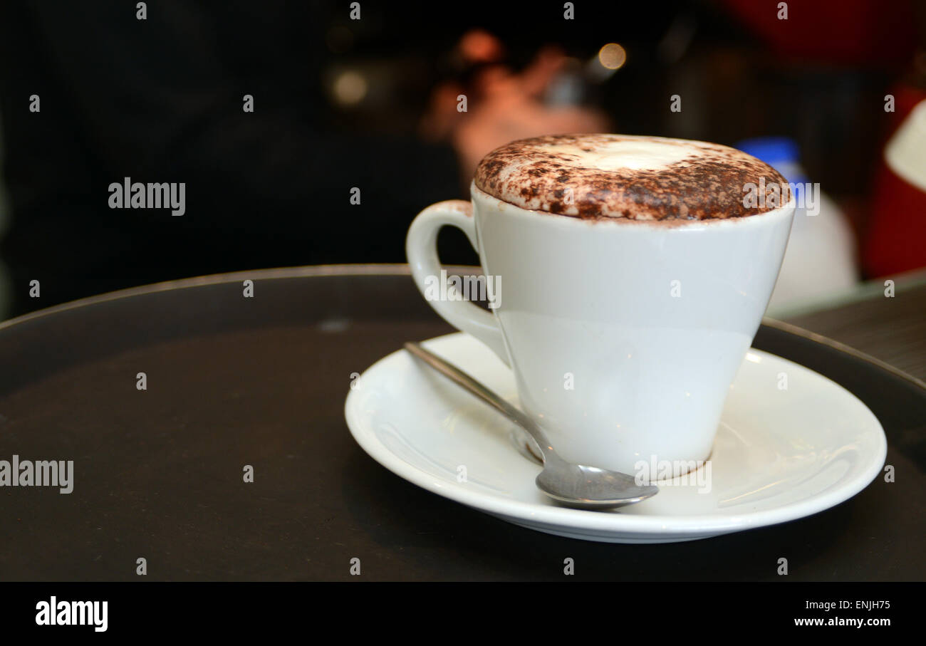 Il caffè fresco con schiuma di latte e cioccolato spolverati sulla parte superiore Foto Stock