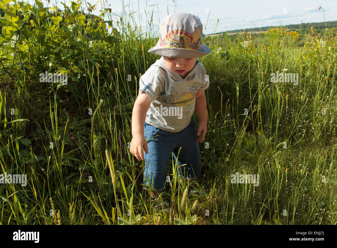 Il ragazzino in un cappuccio va in un'erba Foto Stock
