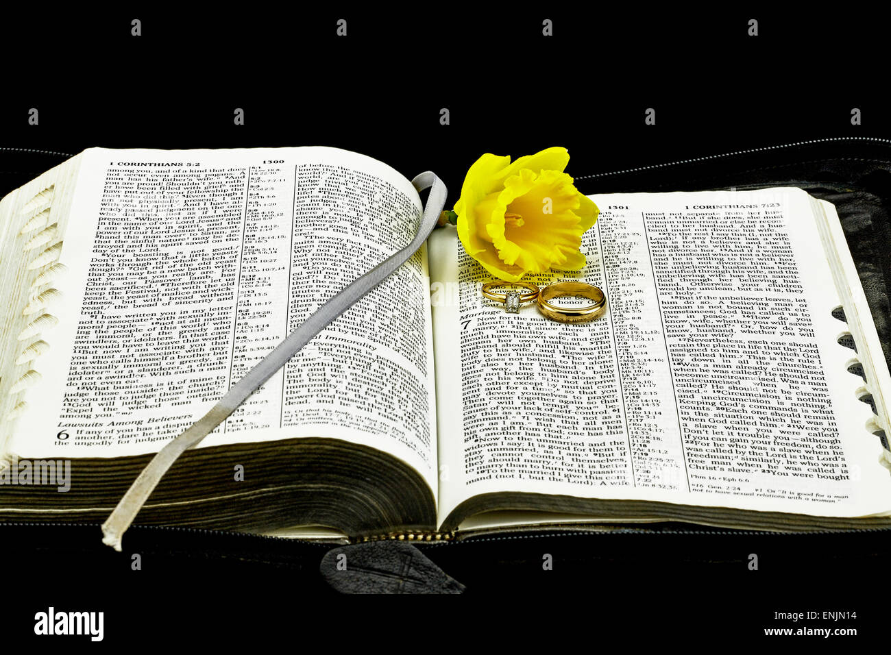 La Bibbia sul matrimonio con gli anelli di nozze e fiori Foto Stock
