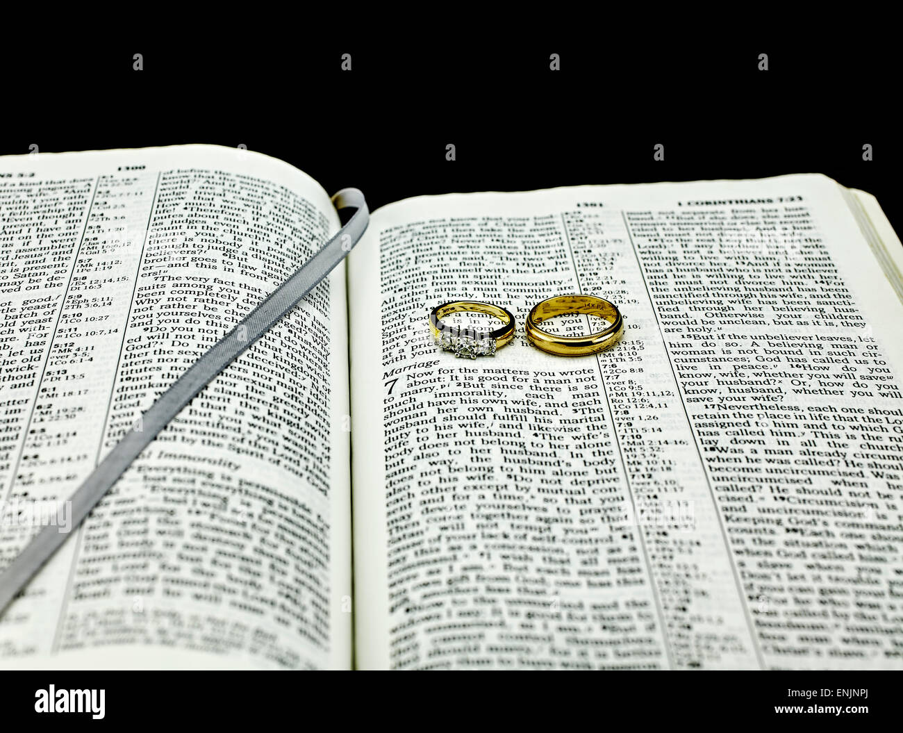 Versetto biblico sul matrimonio con due anelli di nozze Foto Stock