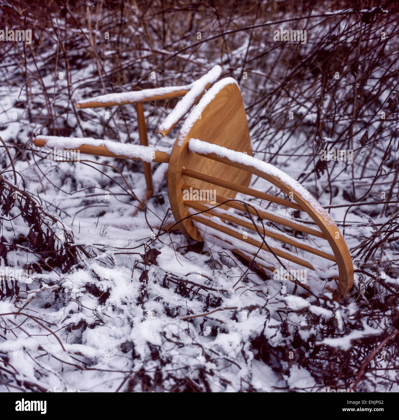 sedia in legno lanciata, neve, scena invernale in giardino Foto Stock