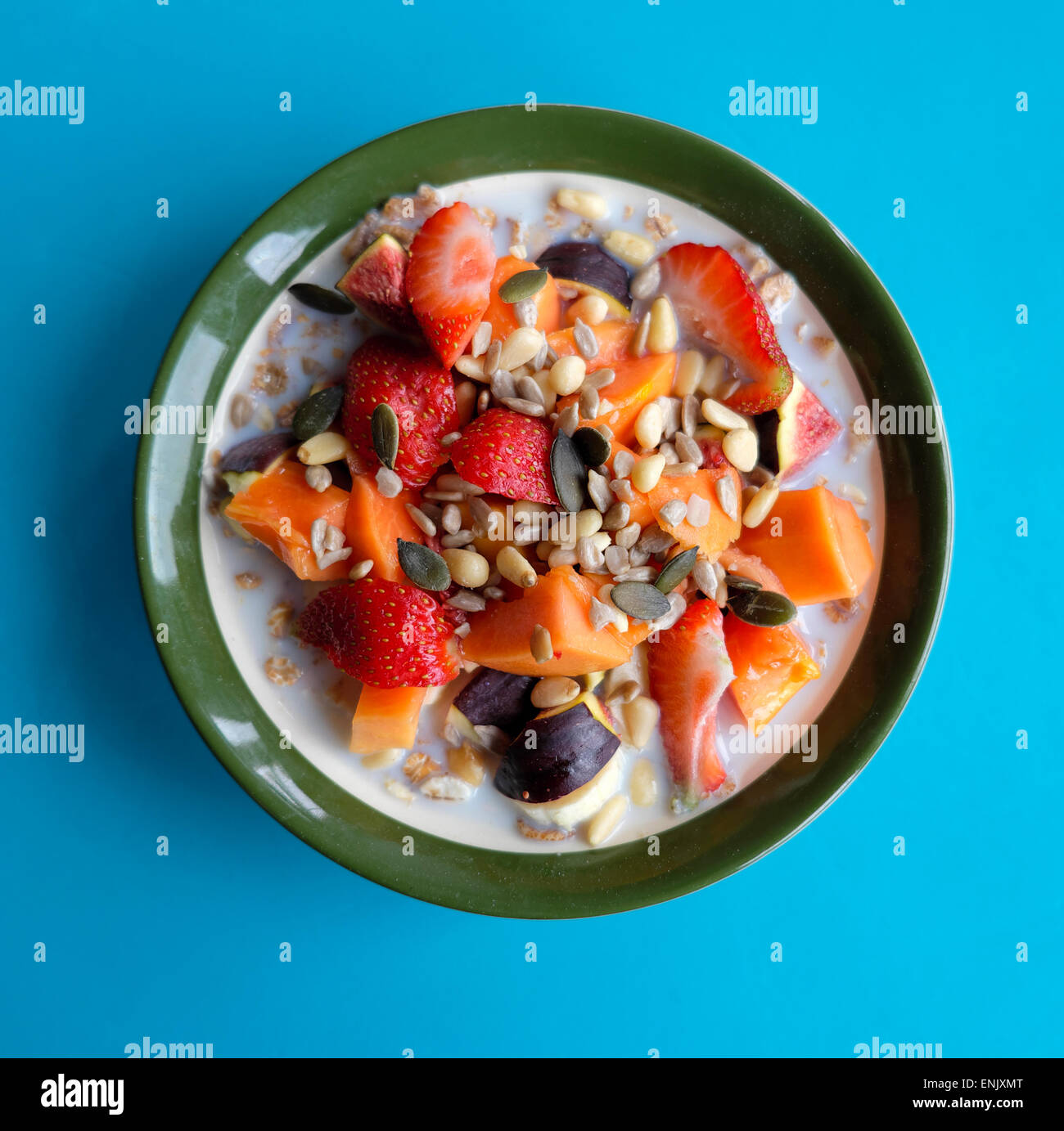 Una ciotola di cibo intero muesli cereali per la prima colazione con semi di frutta fresca, fichi, papaia visto dal di sopra su sfondo blu Londra Inghilterra KATHY DEWITT Foto Stock