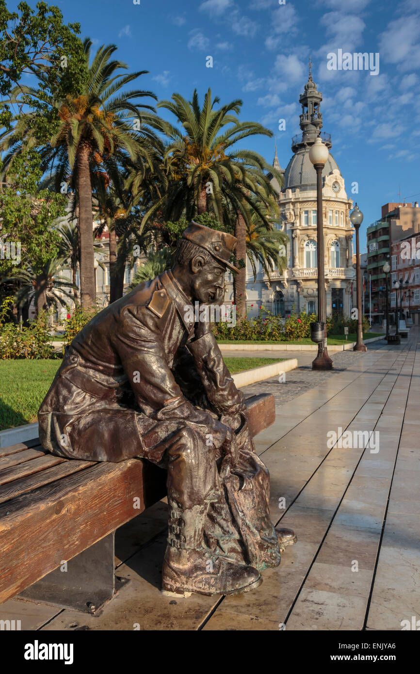 Statua di bronzo di un marinaio su una panca in legno con palme, Municipio sfondo, Cartagena, Regione di Murcia, Spagna, Europa Foto Stock