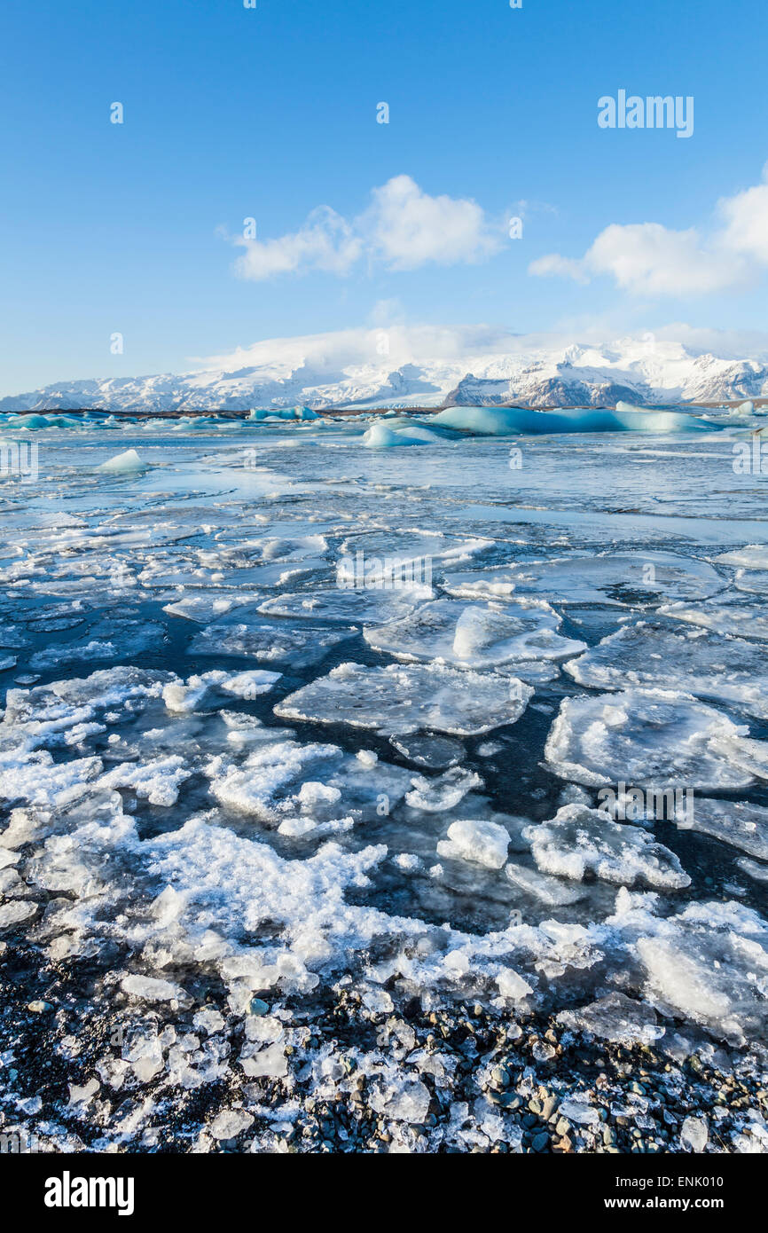 Le montagne alle spalle l'acqua congelata di Jokulsarlon laguna Iceberg, Jokulsarlon, sud est Islanda, regioni polari Foto Stock