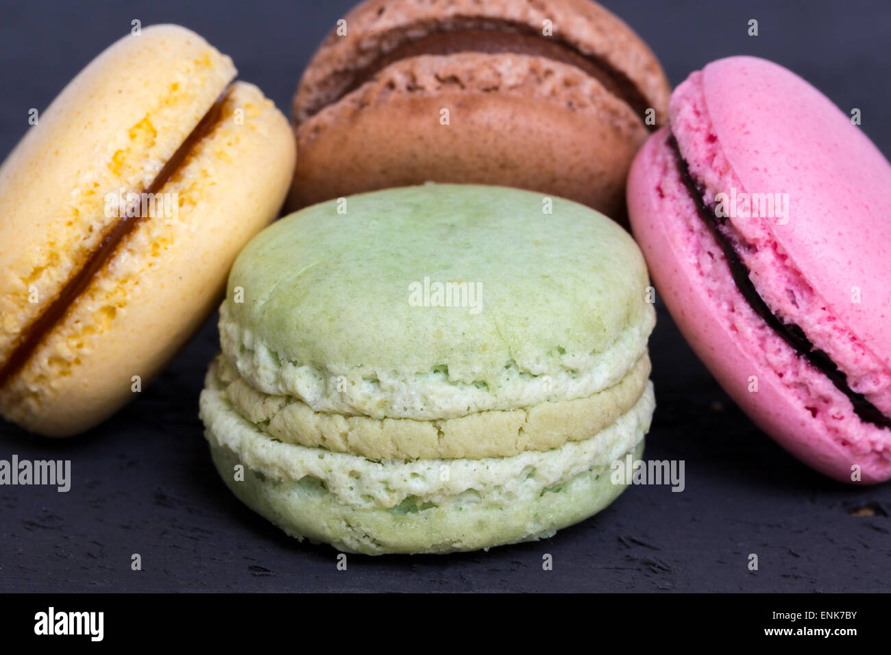 Macaron colorati su un legno nero. Foto Stock