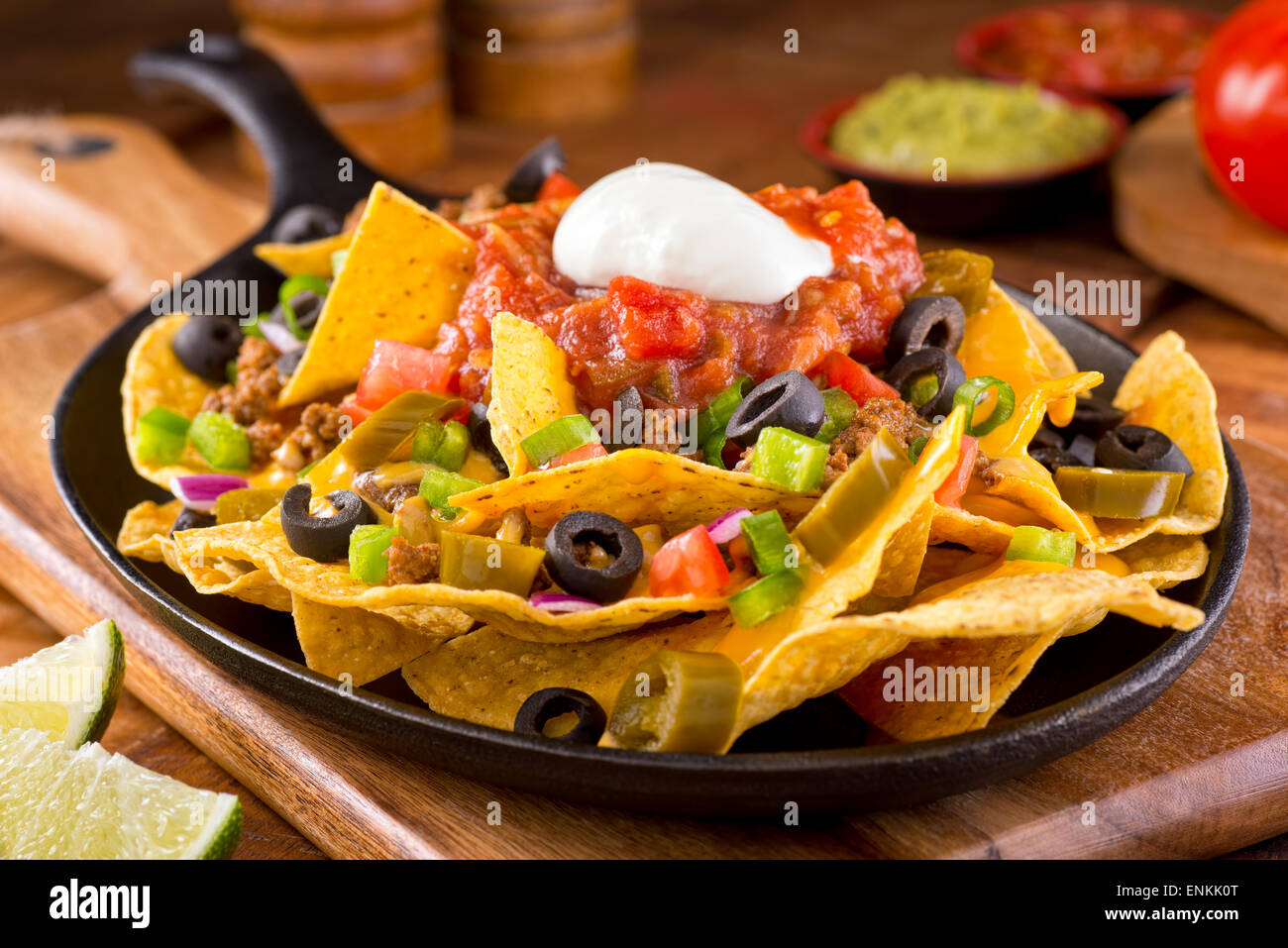 Una piastra di deliziose tortillas nachos con formaggio fuso e salsa di carne di manzo macinata, i peperoncini jalapeno, cipolla rossa, cipollotti, pomodoro, b Foto Stock