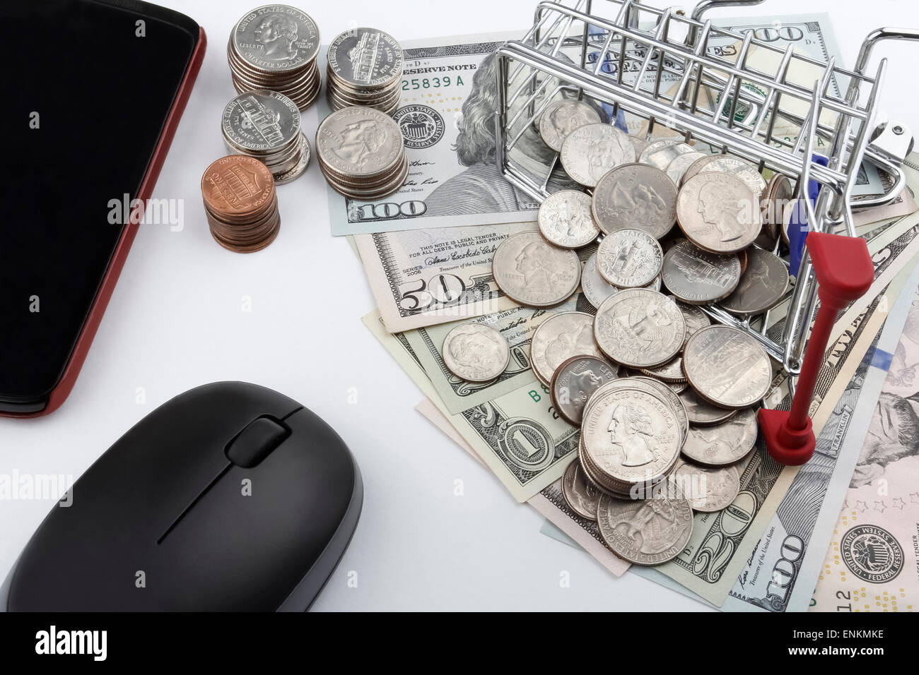 Carrello con monete, banconote, uno smart phone e un mouse. Foto Stock