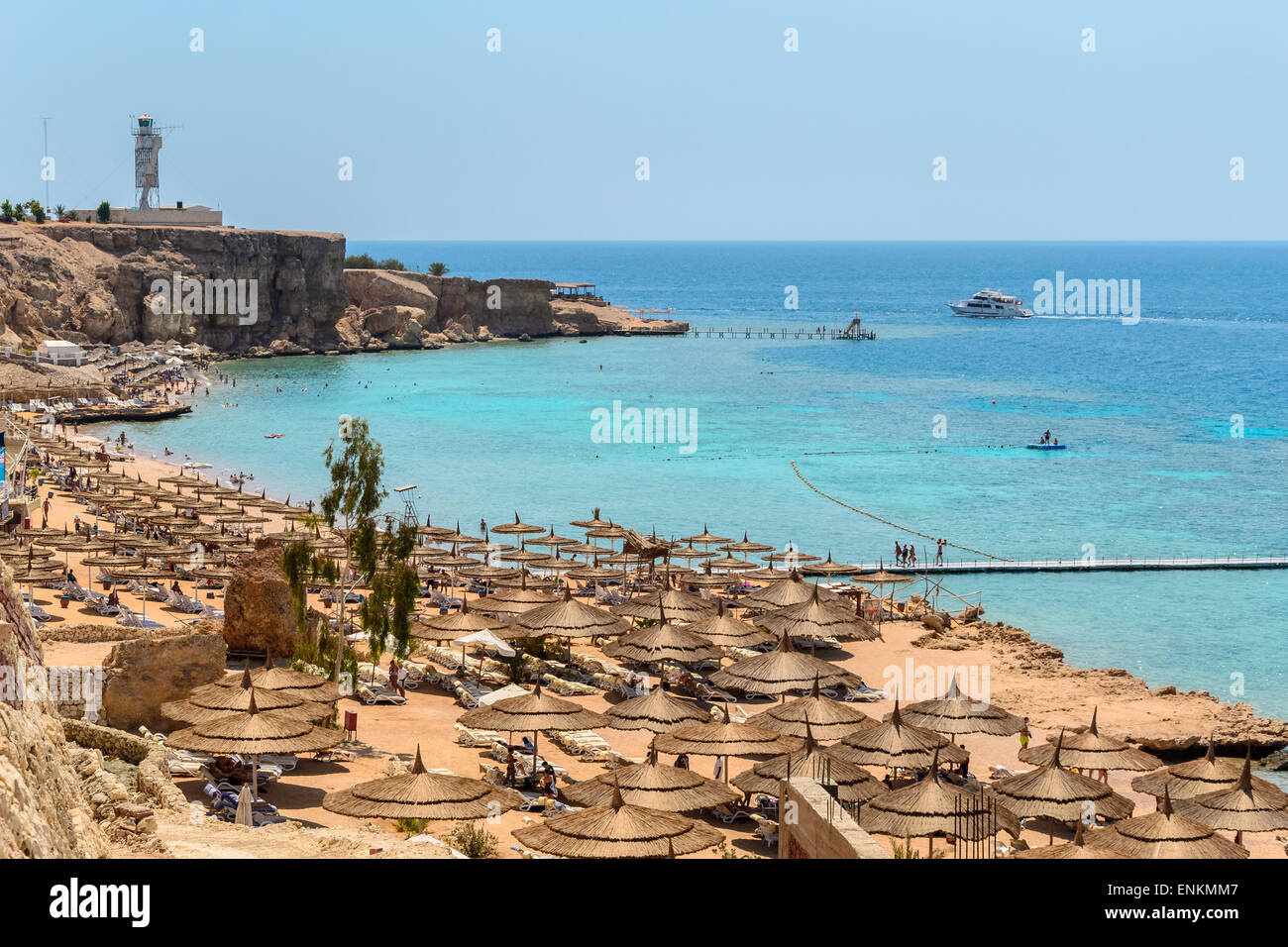 Nella foto una tipica spiaggia egiziano nel Mar Rosso con legno e ombrelloni di paglia e mare turchese. Foto Stock