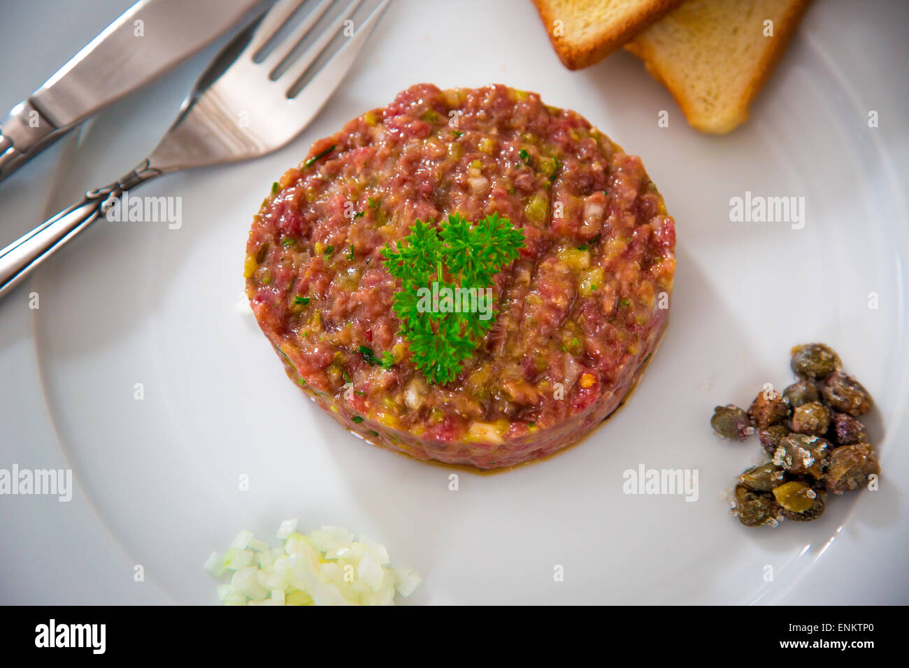 Bistecca tartara con cipolla, capres e pane tostato Foto Stock
