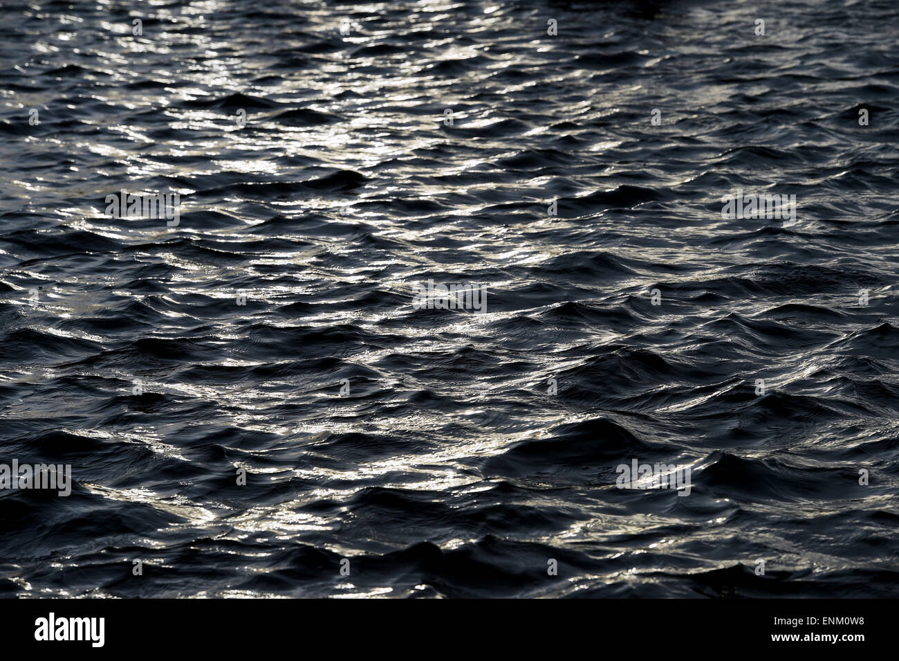 Sun glinting di acqua ondeggiano increspature Foto Stock