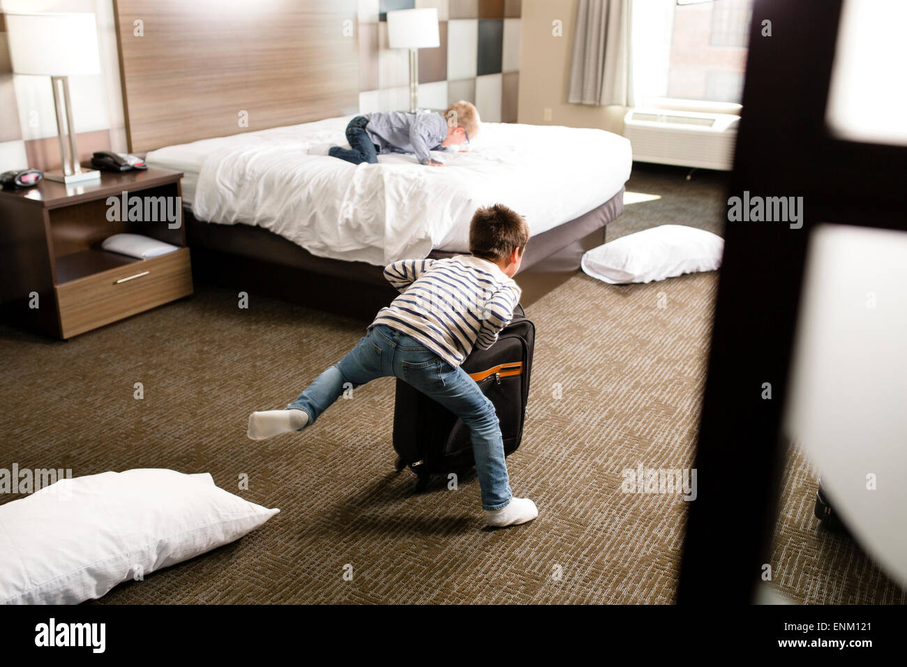 Due ragazzi giocare in una stanza del motel. Foto Stock