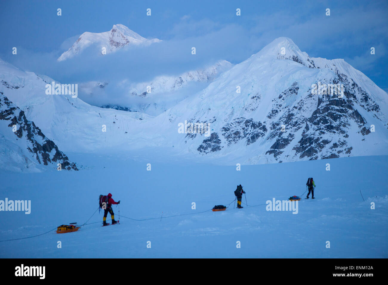 Un team di tre alpinisti sul loro modo al campo base dopo aver raggiunto la vetta del monte McKinley, noto anche come Denali in Alaska. Mount Hunter in background. Foto Stock