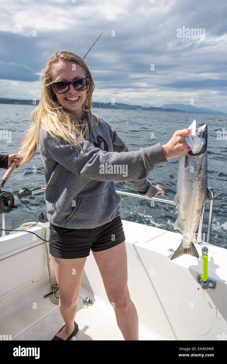 Nord America, Canada, British Columbia, Discovery Passage, Vancouver Island, Pesca al salmone, donna che tiene catturato Coho salmone Foto Stock