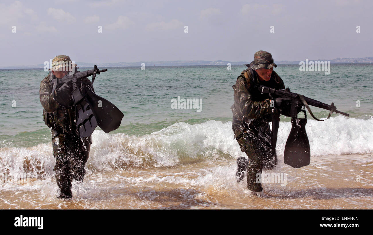 Massa giapponese di autodifesa nuotatore scout funzionamento speciale commandos emergere al di fuori dell'acqua mentre praticando tecniche come parte del Giappone osservatore Programma di scambio a Kin Blue beach Aprile 28, 2015 a Okinawa, Giappone. Foto Stock