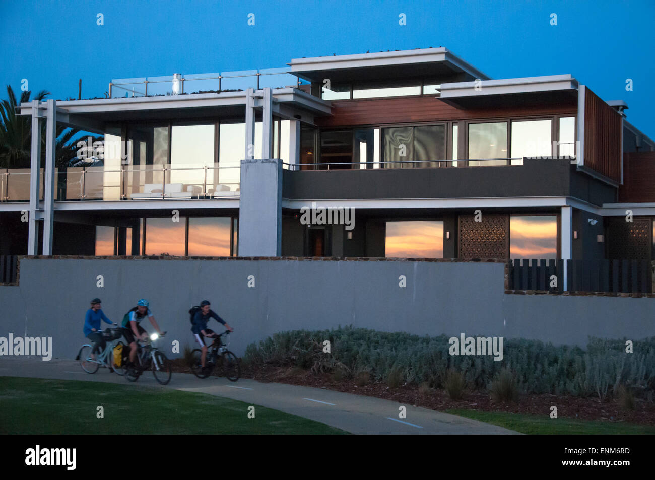 I ciclisti passando una spiaggia di lusso home su Brighton il 'Golden Mile', Melbourne, Australia Foto Stock