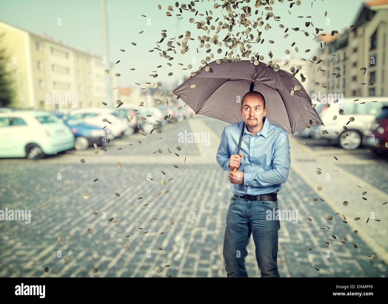 Uomo con ombrellone e monete in euro la pioggia Foto Stock