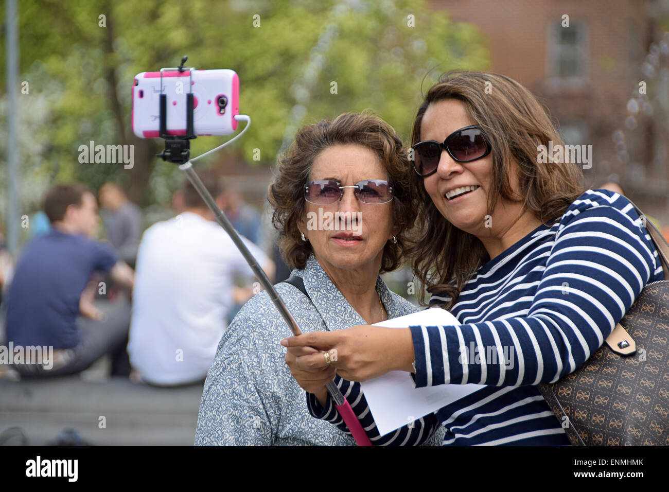 Due donne turisti prendendo un selfie vicino alla fontana di Washington Square Park nel Greenwich Village di New York City Foto Stock