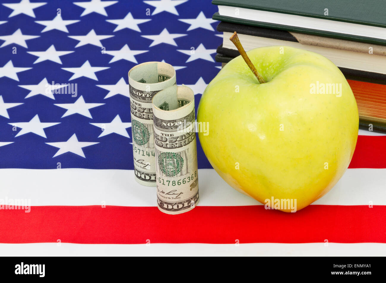 Simbolico rappresentante Apple di istruzione posti con moneta americana, bandiera nazionale, e libri. Foto Stock