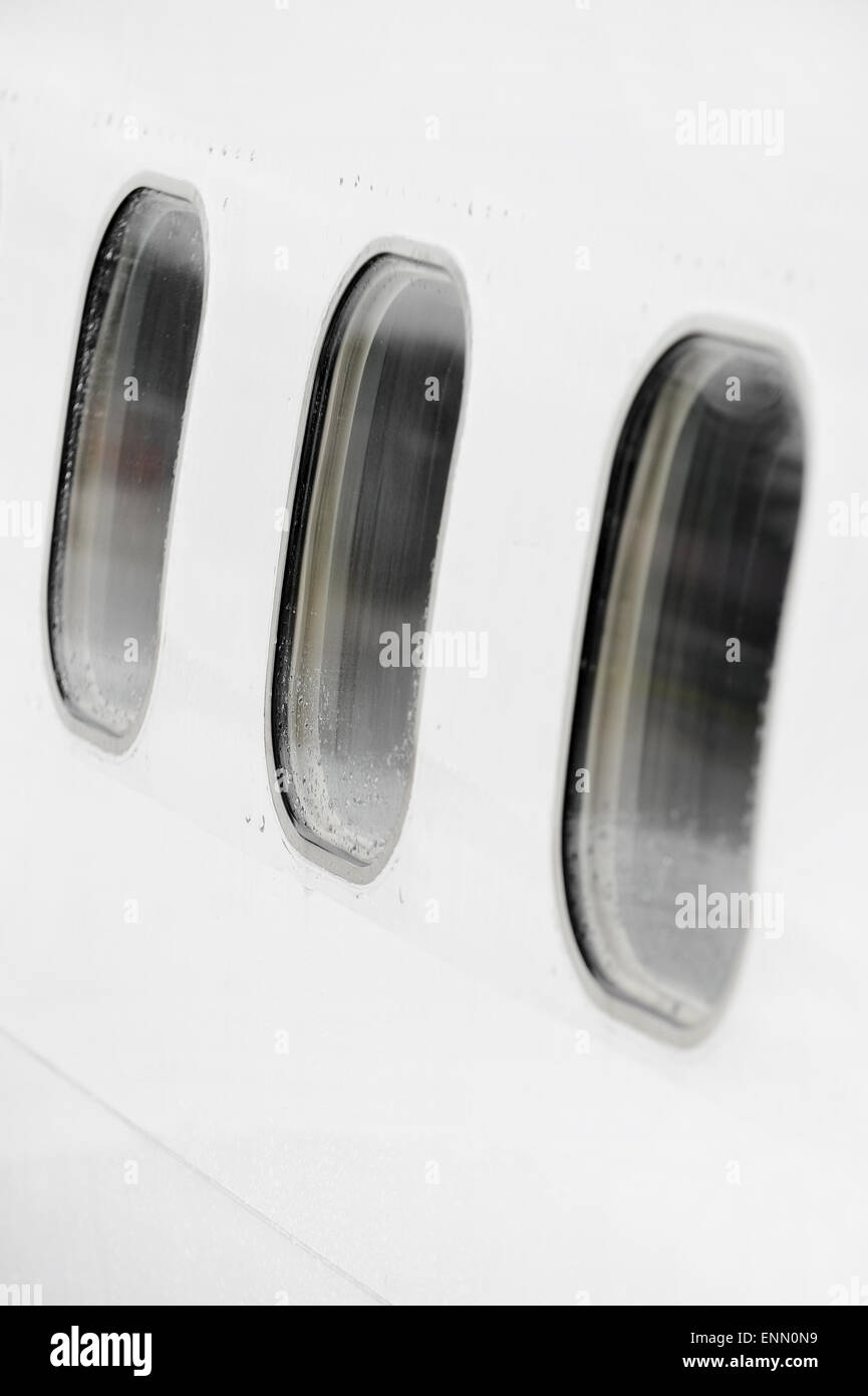 Aeroplano di windows in una fila con gocce di pioggia su di essi Foto Stock