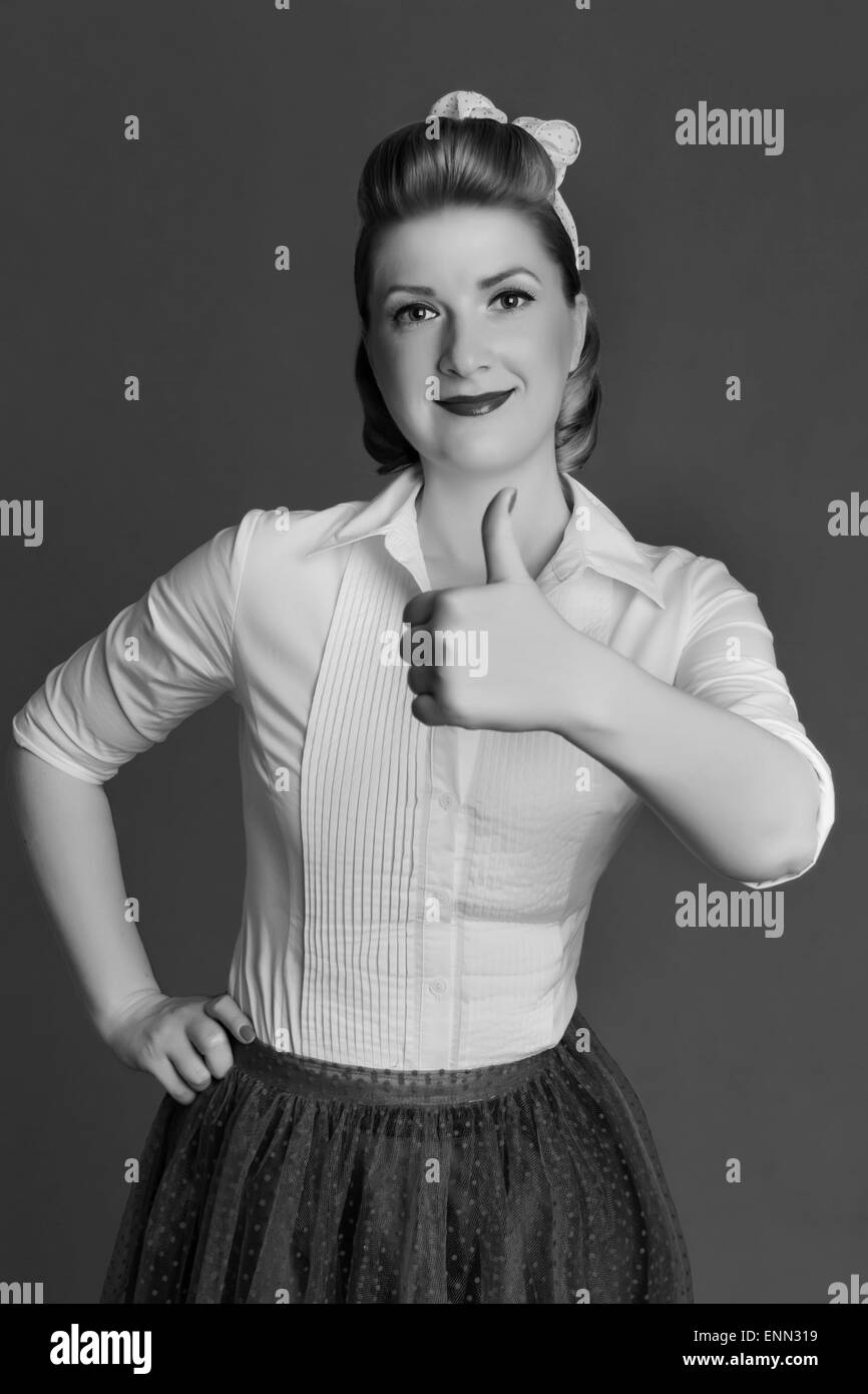 Sorridente ragazza mostra un pollice in su la groppa Foto Stock