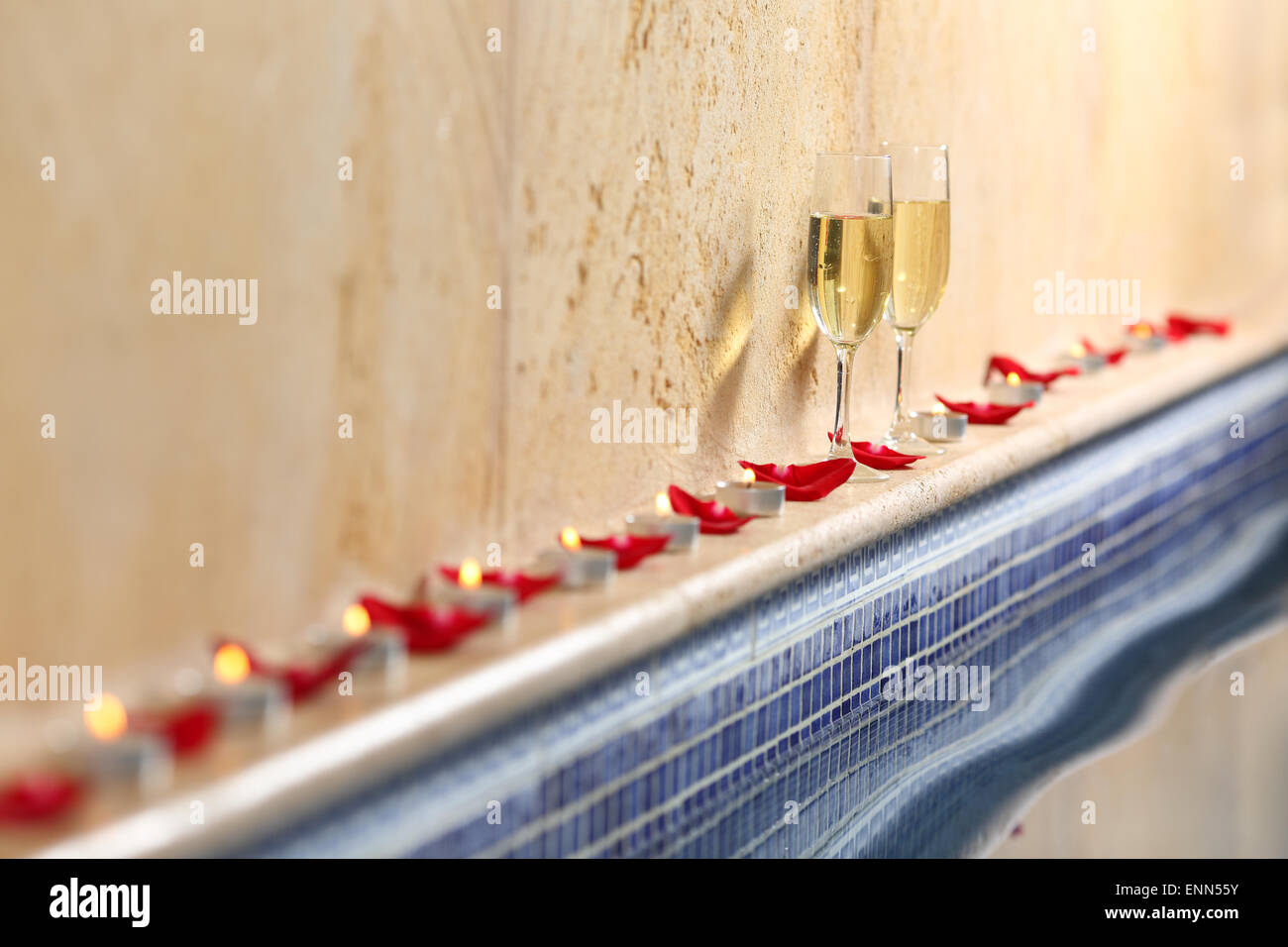 Close up di candele e petali di rosa wit di coppe di champagne in una celebrazione spa concept Foto Stock