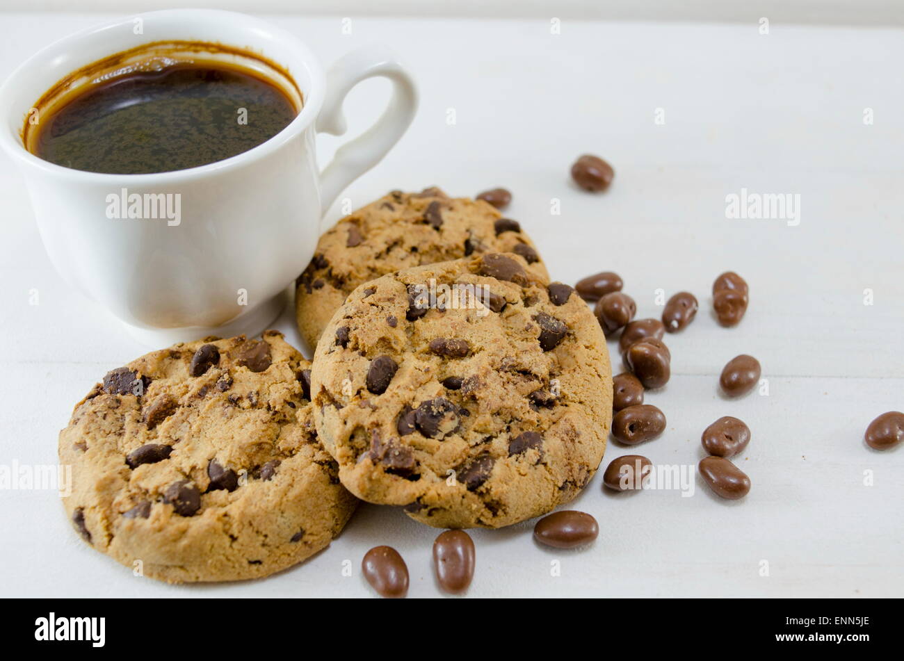 I biscotti al cioccolato e una tazza di caffè su bianco Foto Stock