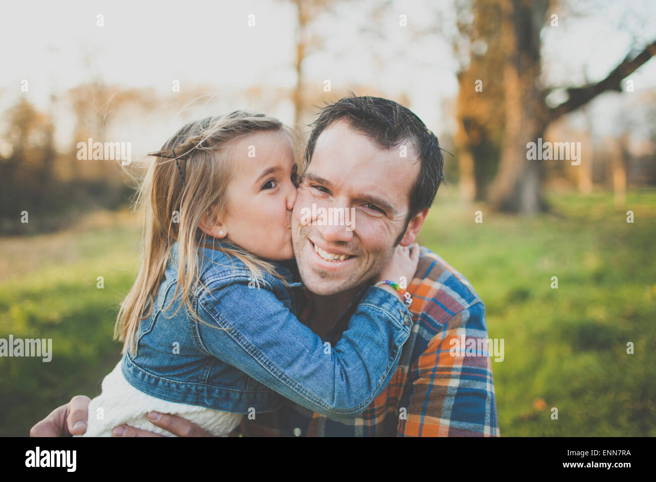 Una giovane ragazza bacia il papà sulla guancia. Foto Stock