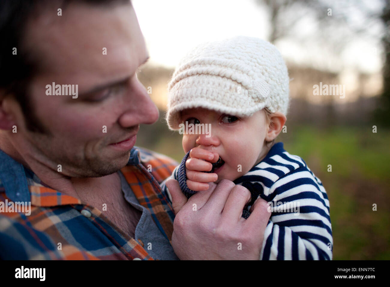 Un padre tiene e consola il suo giovane figlia mentre lei grida. Foto Stock
