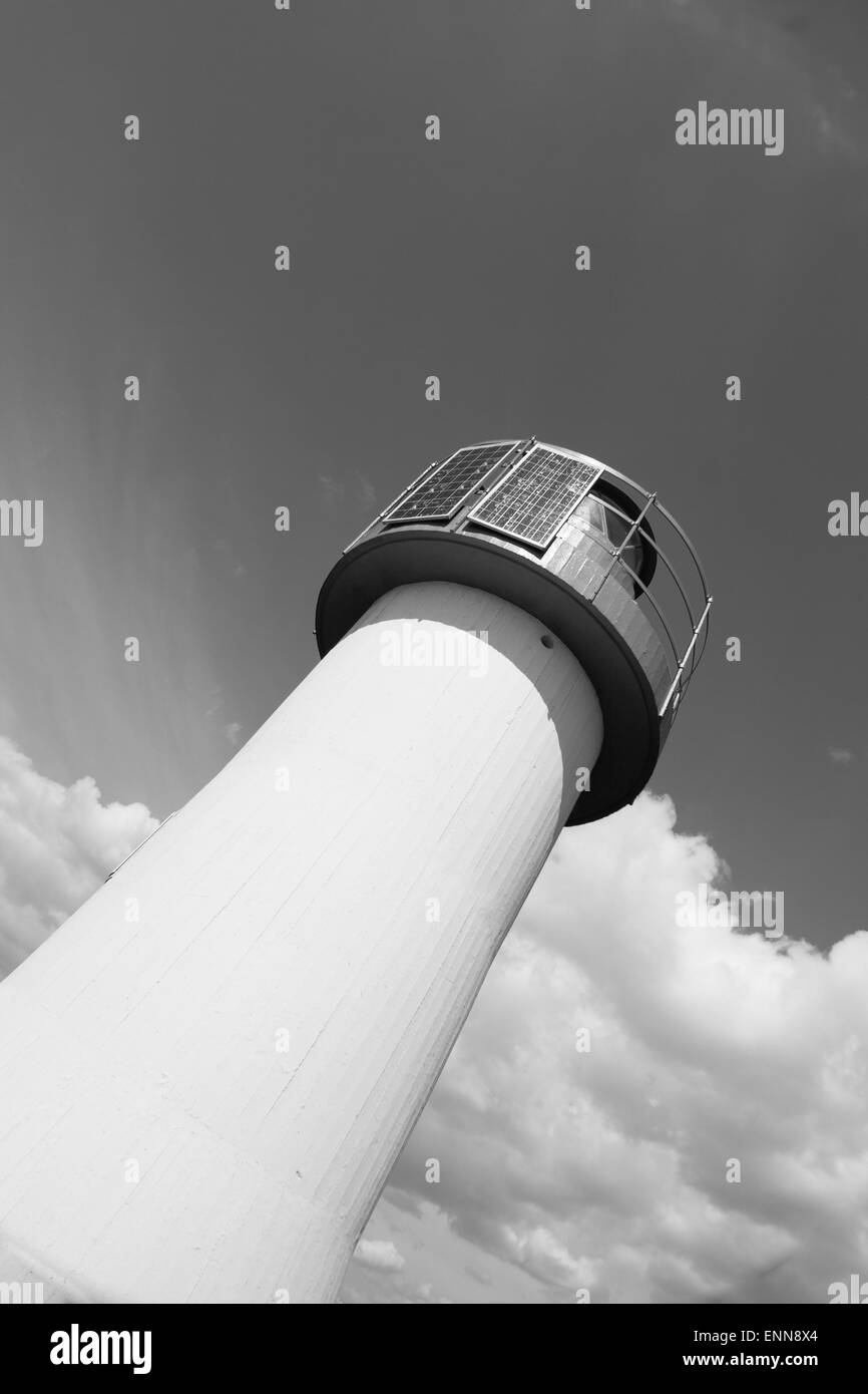 Faro cielo fotovoltaico . Marchio del mare presso il porto con il cielo blu con nuvole in background Foto Stock