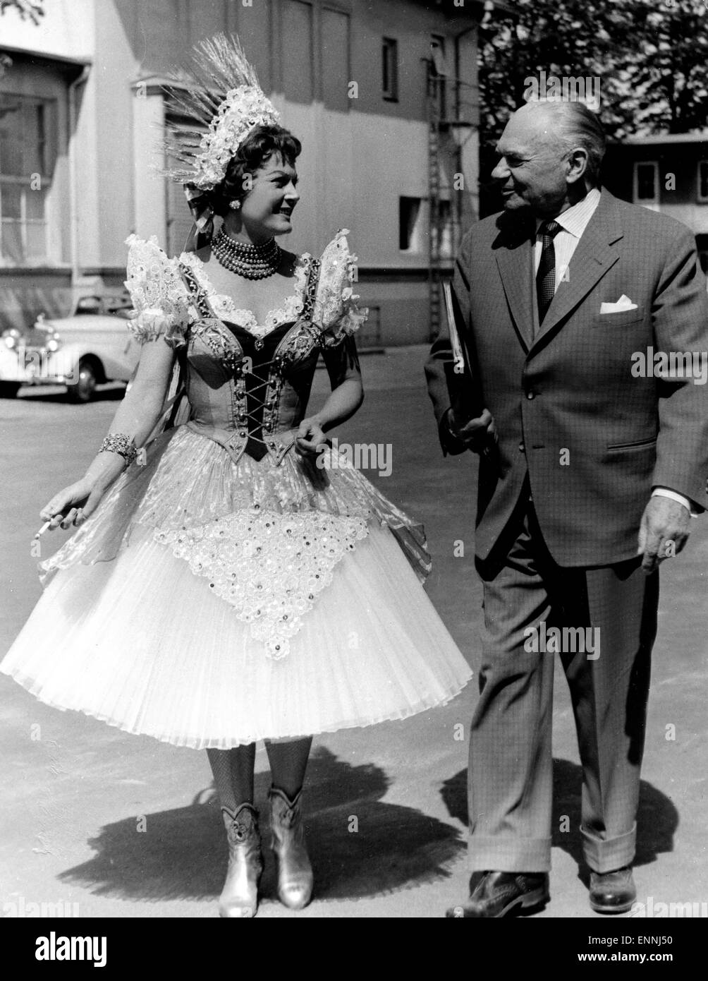 Marika Rökk in einer Drehpause im Kostüm und mit Zigarette mit ihrem 1964 verstorbenen Ehemann, dem Regissuer Georg Jacoby. Foto Stock