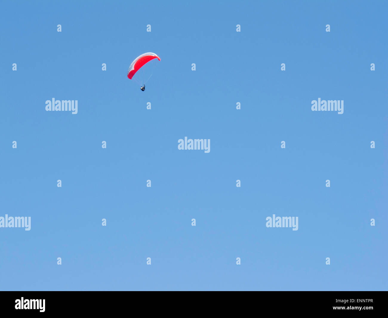 Deltaplano con un baldacchino rosso contro un cielo blu chiaro Foto Stock