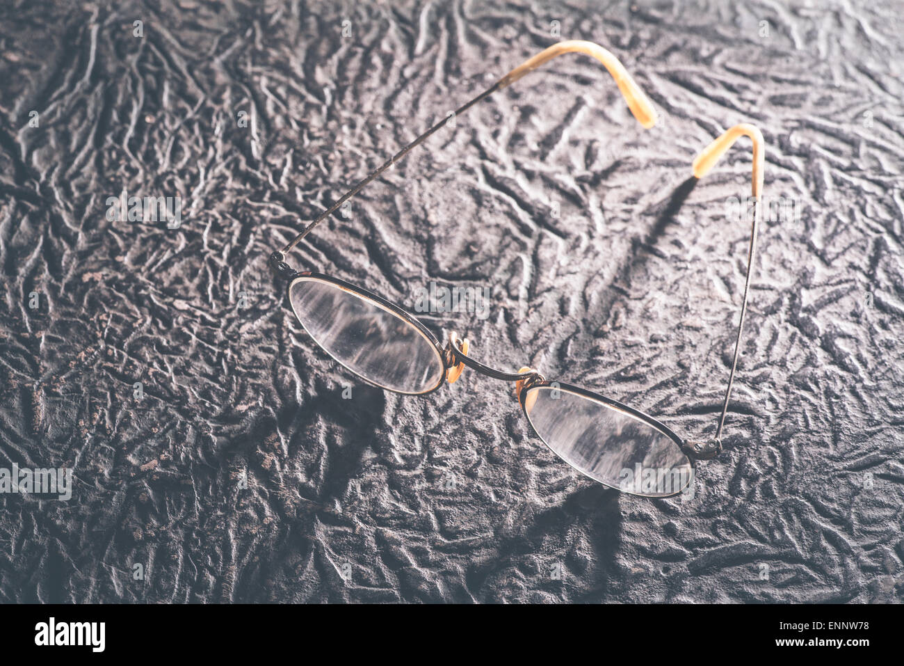 Vecchio vintage occhiali rotondi e album foto in pelle. Foto Stock