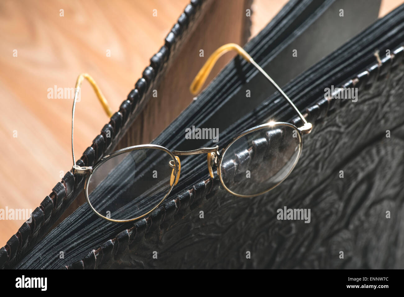 Vecchio vintage occhiali rotondi e album foto in pelle. Foto Stock