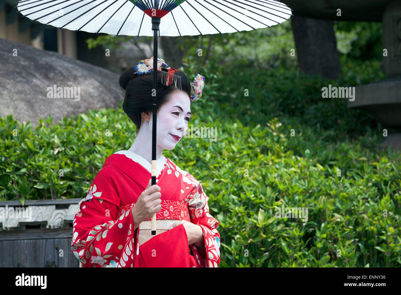 Geisha in abbigliamento tradizionale e olio-ombrello di carta (wagasa) a Kyoto, Giappone Foto Stock