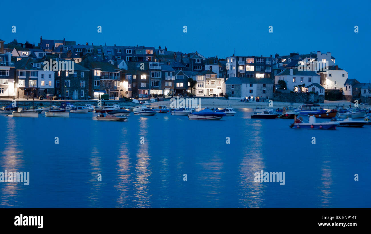St Ives Harbour, Cornwall di notte, un blu ora girato con le barche in acqua e il grazioso cottage dell'area Downalong. Foto Stock