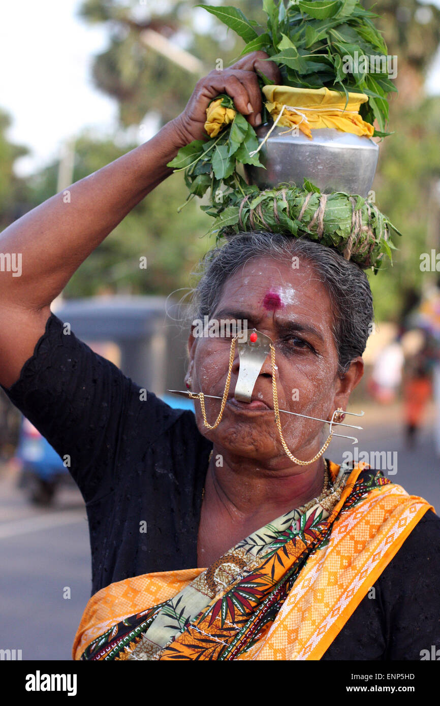 Donna con le guance e la linguetta forata da 2 spiedini o 'vels', uno attraverso la linguetta, uno attraverso le guance, a un Indù Tamil processione in Sri Lanka Foto Stock