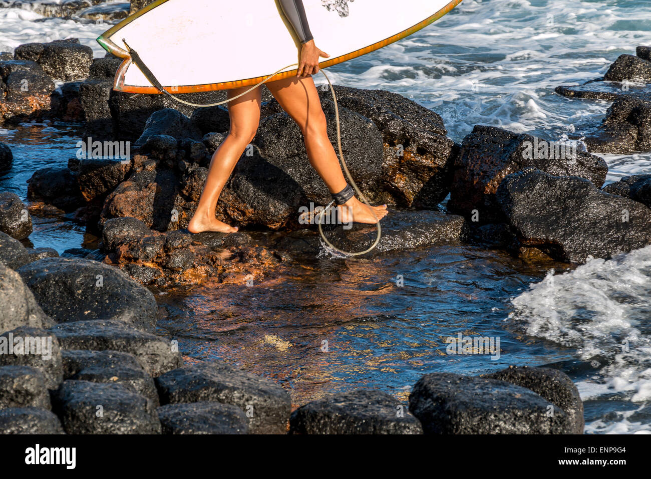 Un surfista femmina è pronta per uscire e andare in surf a tropical reef break. Foto Stock