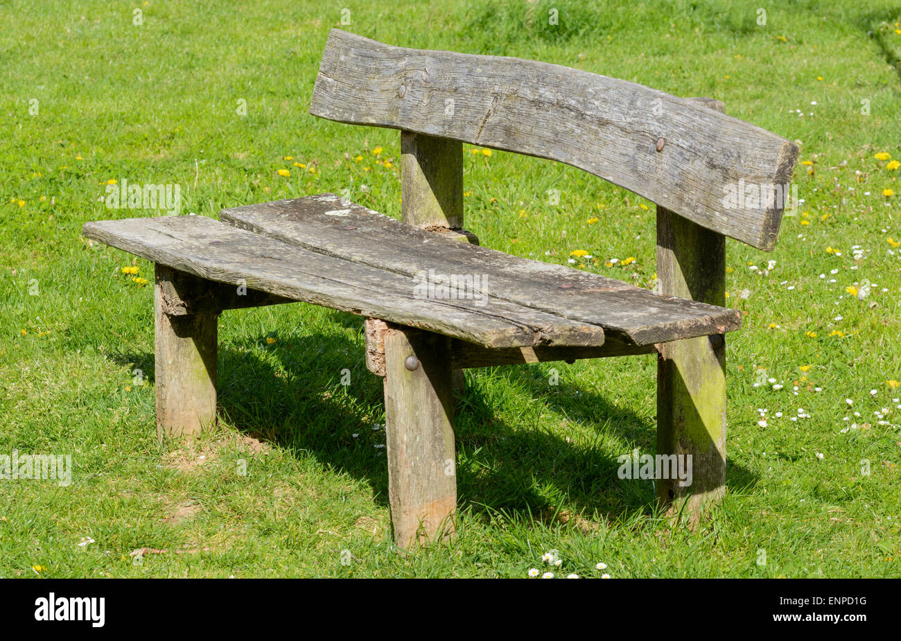 Rustico panca in legno sul prato di un parco. Foto Stock