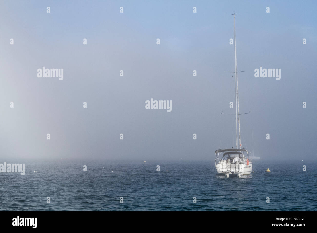 Yacht a vela nella nebbia ormeggiata nella baia di Cabrera Island, una bioreserve a Maiorca, Spagna Foto Stock