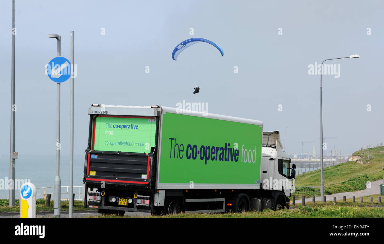 Brighton, Regno Unito. Il 10 maggio, 2015. Un parapendio vola passato un camion lungo la A259 sulla strada costiera tra Brighton e Rottingdean come calma le condizioni meteorologiche erano perfette per battenti oggi. Credito: Simon Dack/Alamy Live News Foto Stock