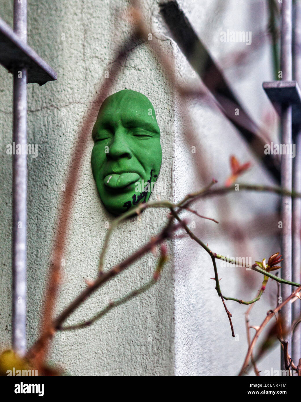 Urban street art - verde 3-D self portrait, una faccia scultura di Gregos su un edificio della città di Berlino Foto Stock
