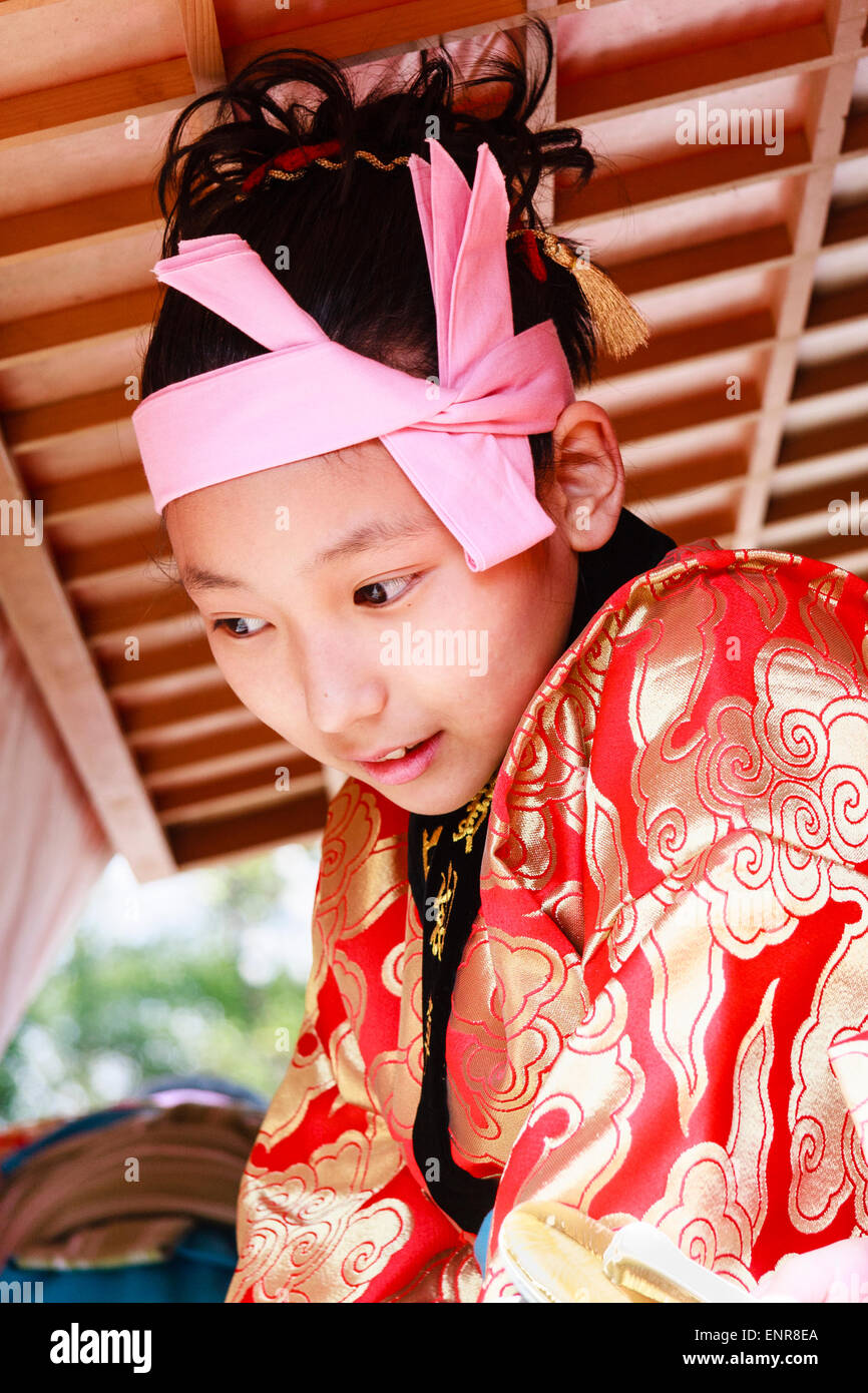 Primo piano di bambino giapponese, ragazzo, 7-8 anni, con il kimono rosso e  la fascia rosa, appoggiandosi a parlare con un altro. Espressione felice  Foto stock - Alamy