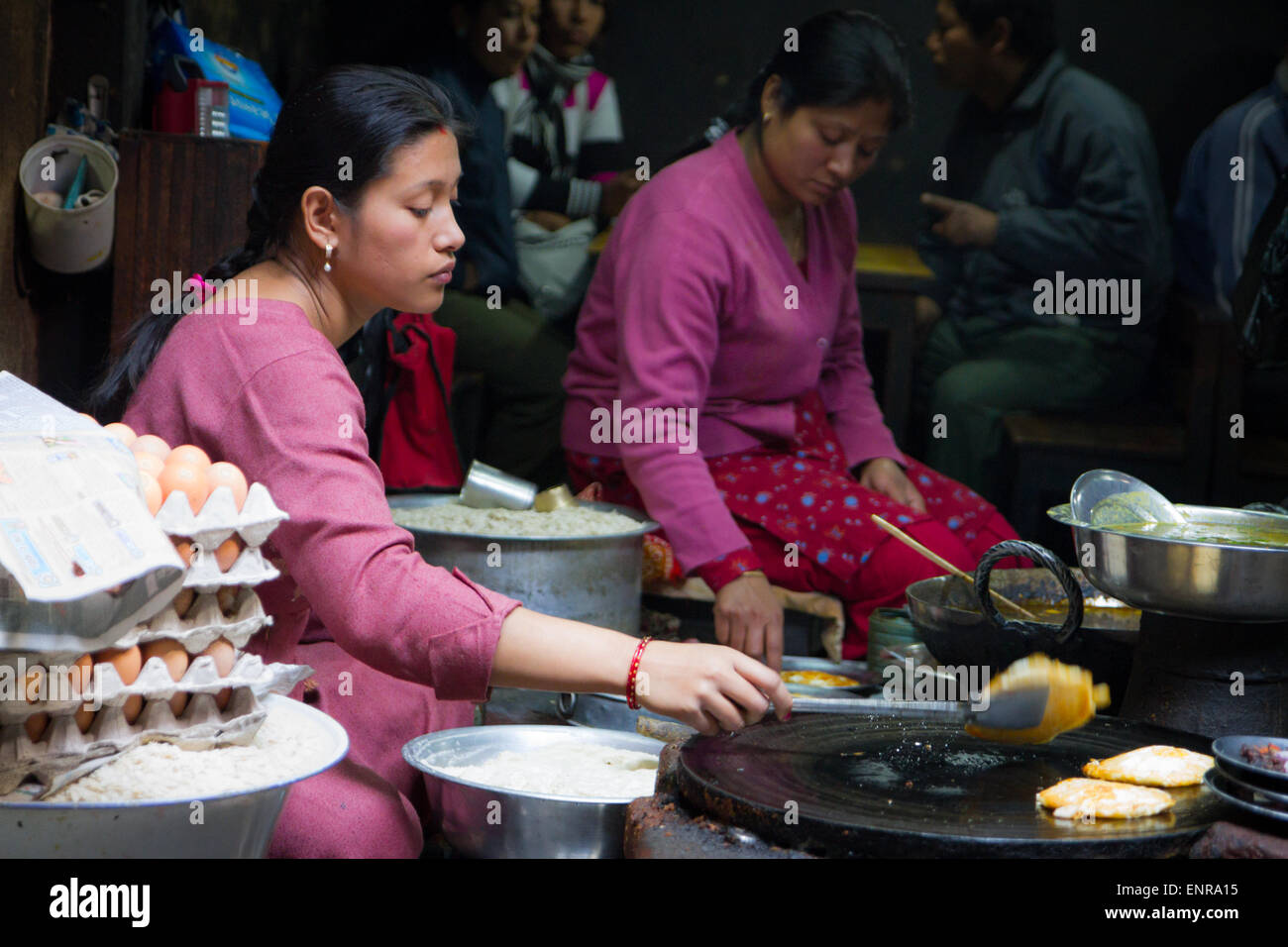 Le donne con dosa di cucina nel ristorante Newari nella storica città di Patan, Kathmandu, Nepal Foto Stock