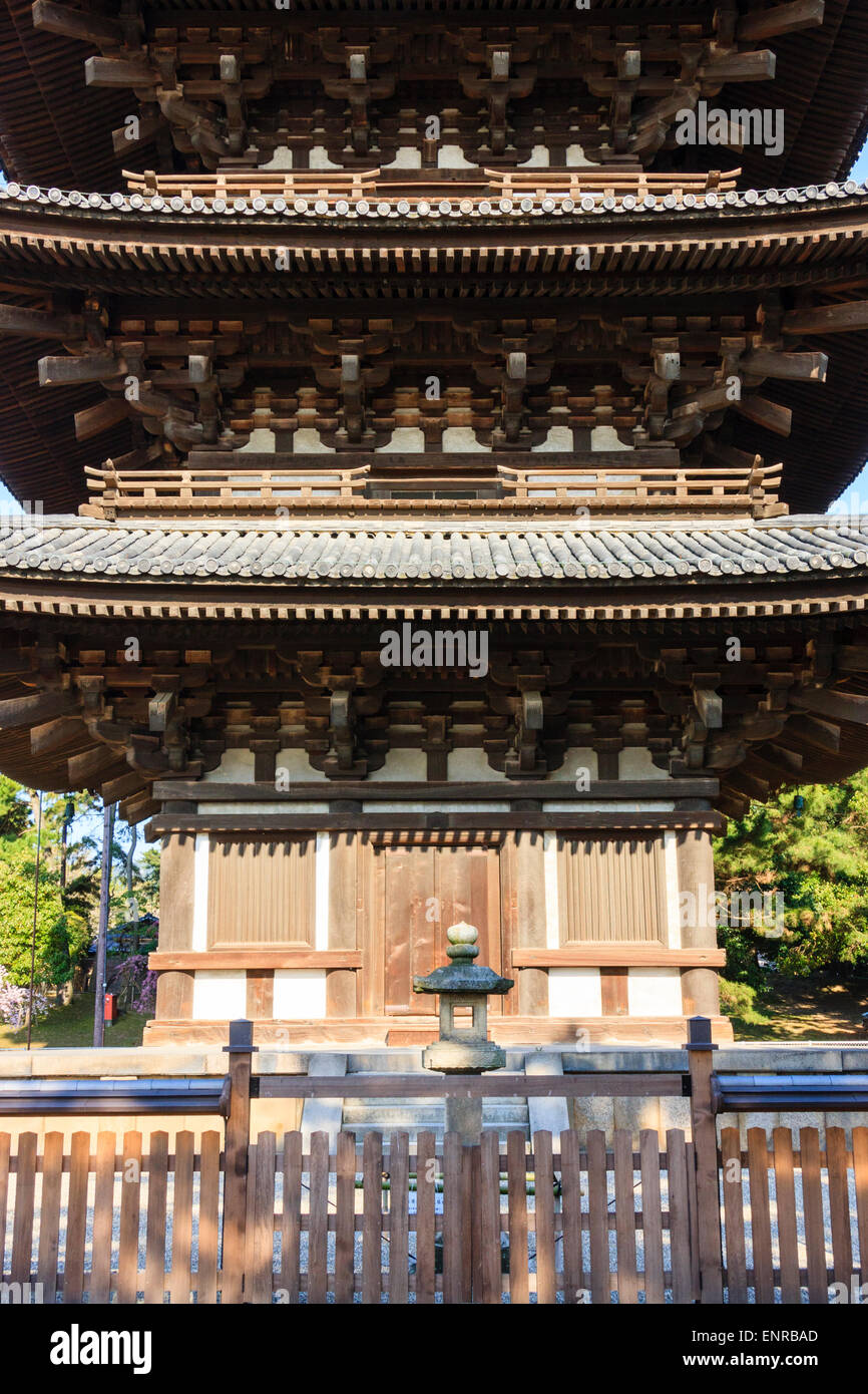 I primi tre piani e la porta della pagoda di legno a cinque piani al tempio di Kofuku a Nara, Giappone. Stretto da vicino, con forte luce solare. Foto Stock